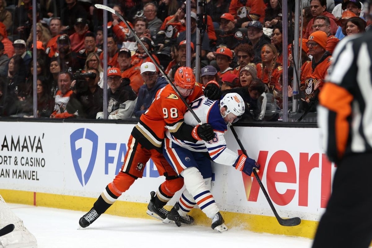 Apr 24, 2026; Anaheim, California, USA;  Anaheim Ducks defenseman Pavel Mintyukov (98) and Edmonton Oilers left wing Zach Hyman (18) fight for the puck during the third period of game three of the first round of the 2026 Stanley Cup Playoffs at Honda Center. Mandatory Credit: Kiyoshi Mio-Imagn Images