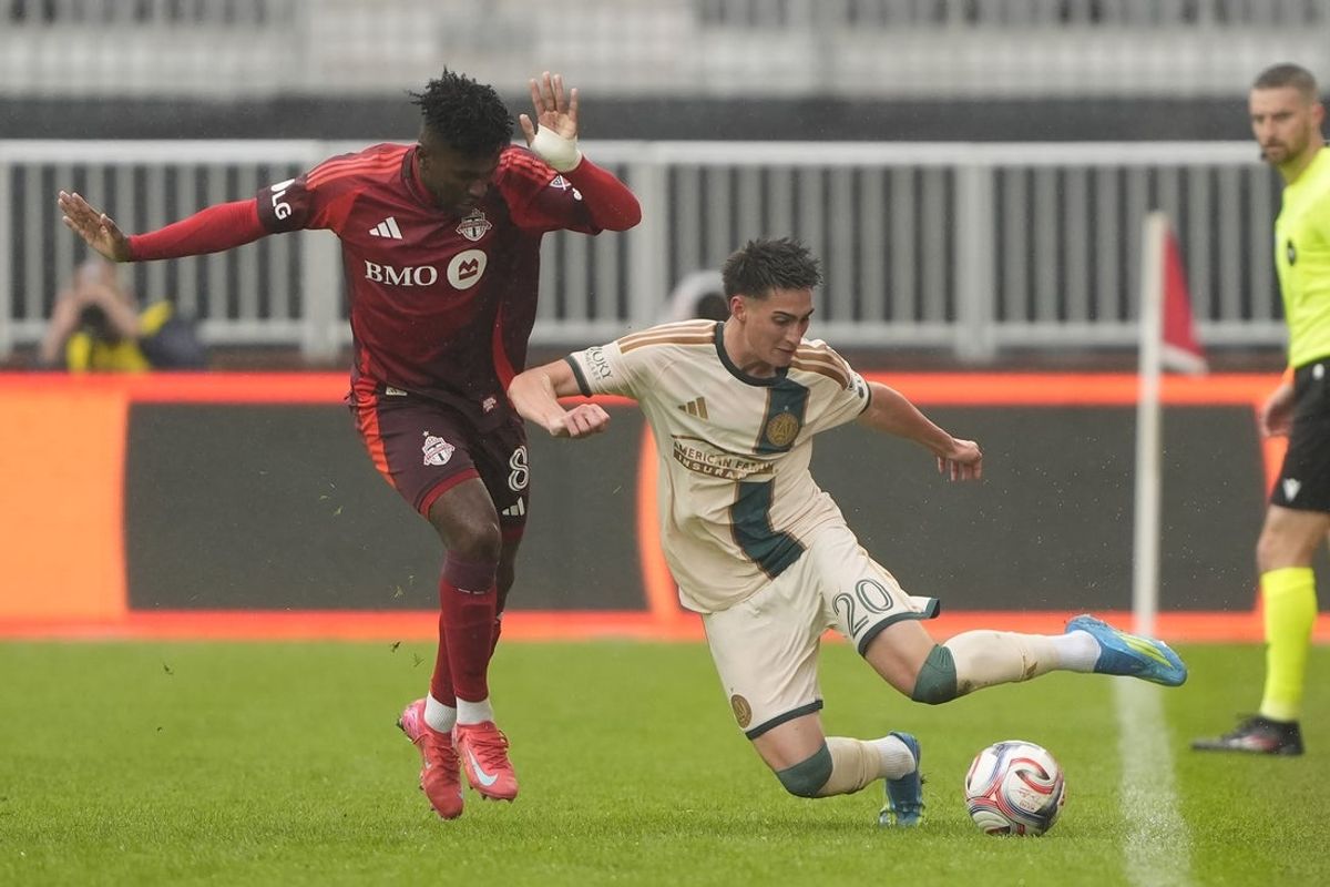 Apr 25, 2026; Toronto, Ontario, CAN; Atlanta United FC midfielder Luke Brennan (20) keeps th eball in play as Toronto FC midfielder Jose Cifuentes (8) defends during the first half at BMO Field. Mandatory Credit: John E. Sokolowski-Imagn Images