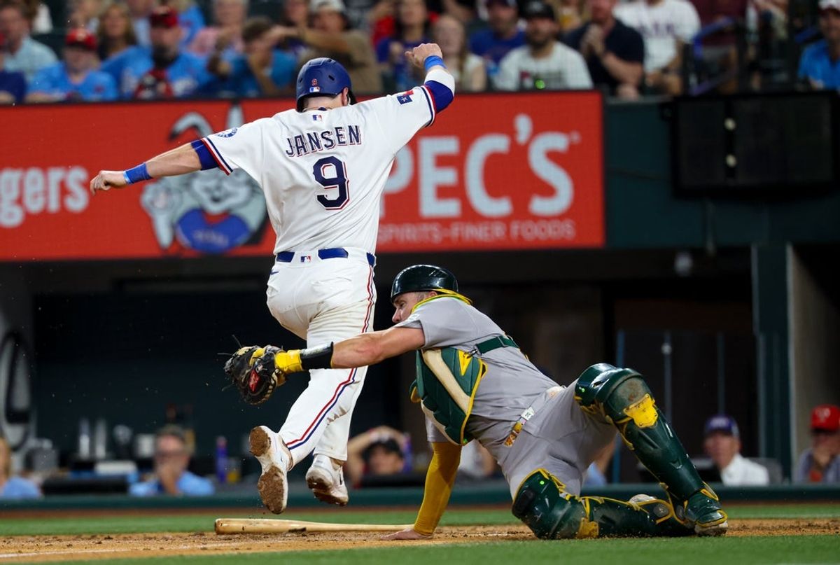 Apr 25, 2026; Arlington, Texas, USA; Texas Rangers catcher Danny Jansen (9) scores at home plate as Athletics catcher Austin Wynns (29) attempts to make the tag during the third inning  at Globe Life Field. Mandatory Credit: Kevin Jairaj-Imagn Images