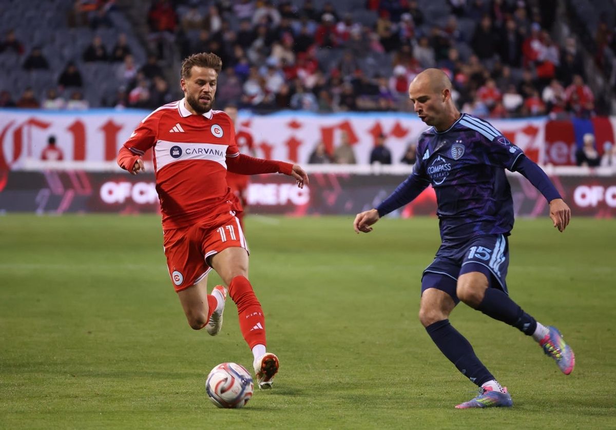 Apr 25, 2026; Chicago, Illinois, USA; Chicago Fire FC midfielder Philip Zinckernagel (11) and Sporting Kansas City defender Jansen Miller (15) battle for control of the ball during the first half at Soldier Field. Mandatory Credit: Talia Sprague-Imagn Images
