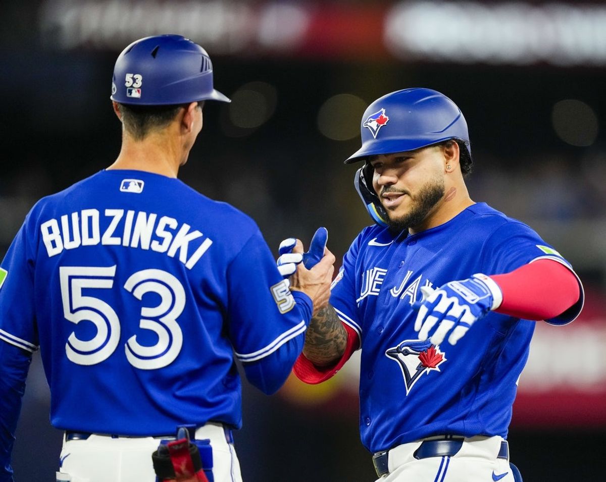 Apr 26, 2026; Toronto, Ontario, CAN; Toronto Blue Jays left fielder Yohendrick Pinango (24) celebrates hitting his first single against the Cleveland Guardians during the fifth inning with first base coach Mark Budzinski (53) at Rogers Centre. Mandatory Credit: Kevin Sousa-Imagn Images