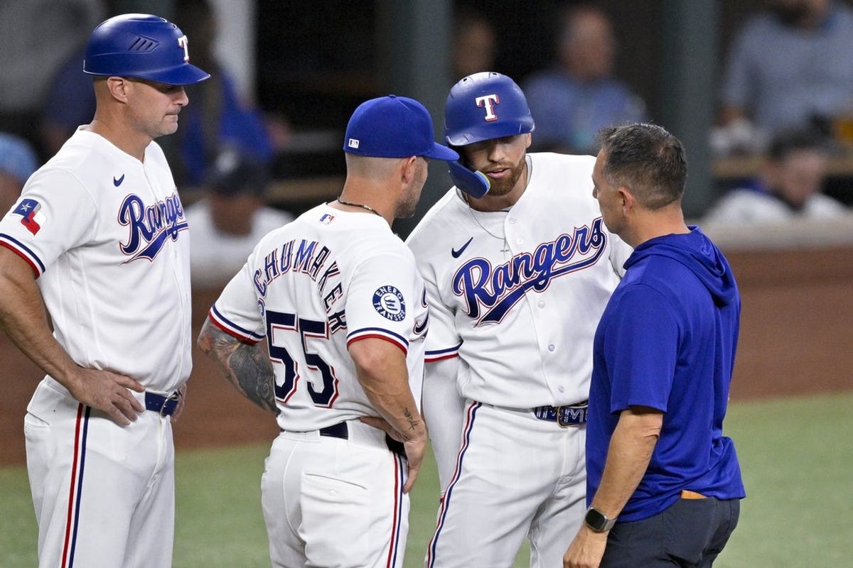 Apr 29, 2026; Arlington, Texas, USA; Texas Rangers manager Skip Schumaker (55) and team staff check on right fielder Brandon Nimmo (24) during the fifth inning against the New York Yankees at Globe Life Field. Mandatory Credit: Jerome Miron-Imagn Images
