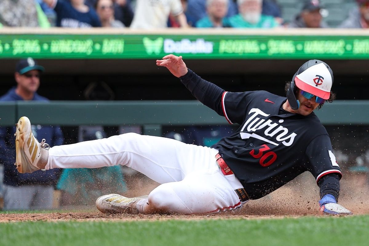 Apr 29, 2026; Minneapolis, Minnesota, USA; Minnesota Twins right fielder James Outman (30) scores on an RBI single hit by catcher Victor Caratini (37) during the eighth inning at Target Field. Mandatory Credit: Matt Krohn-Imagn Images
