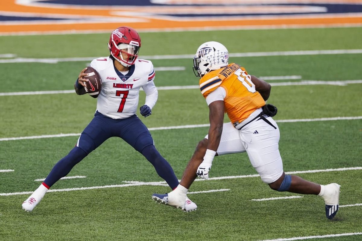 Nov 25, 2023; El Paso, Texas, USA; No. 22 Liberty Flames quarterback Kaidon Salter (7) tries to evade a UTEP Miners defensive end Maurice Westmoreland (0) during the first half at Sun Bowl Stadium.