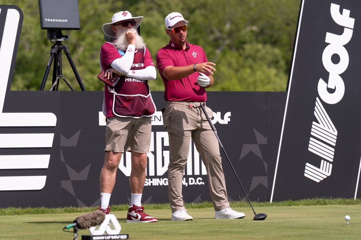 May 8, 2026; Sterling, Virginia, USA; Lucas Herbert talks with his caddie before hitting a drive during the second round of LIV Golf Virginia golf tournament at Trump National Golf Club. Mandatory Credit: John (Jack) Power-Imagn Images