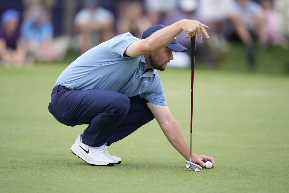 May 8, 2026; Charlotte, North Carolina, USA; Alex Fitzpatrick places his ball on 18 green during the second round of the Truist Championship golf tournament. Mandatory Credit: Jim Dedmon-Imagn Images