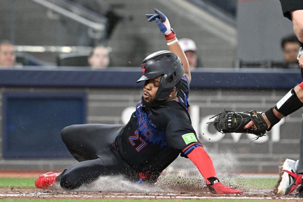May 8, 2026; Toronto, Ontario, CAN;  Toronto Blue Jays first baseman Vladimir Guerrero Jr. (27) scores against Los Angeles Angels catcher Sebastian Rivero (38) in the third inning at Rogers Centre. Mandatory Credit: Dan Hamilton-Imagn Images