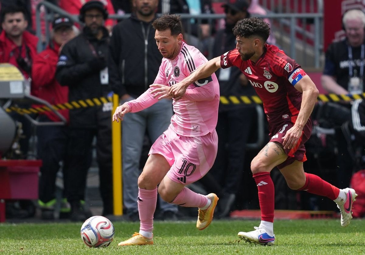May 9, 2026; Toronto, Ontario, CAN; Inter Miami CF midfielder Lionel Messi (10) battles for the ball with Toronto FC midfielder Jonathan Osorio (21) during the first half at BMO Field. Mandatory Credit: Nick Turchiaro-Imagn Images