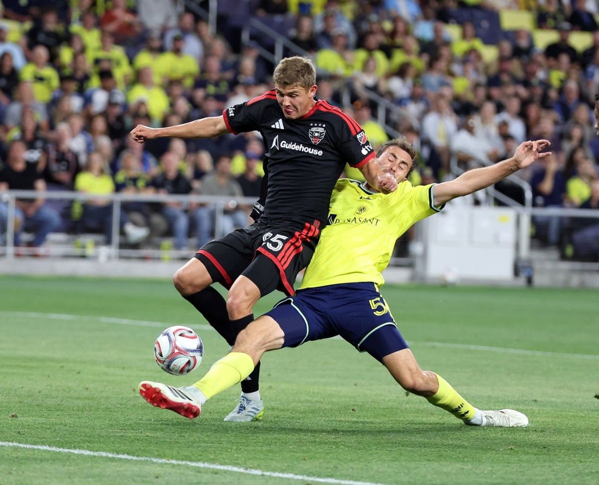 May 9, 2026; Nashville, Tennessee, USA; Nashville SC defender Jack Maher (5) breaks up an attack by D.C. United midfielder Jackson Hopkins (25) during the first half at Geodis Park. Mandatory Credit: Alan Poizner-Imagn Images