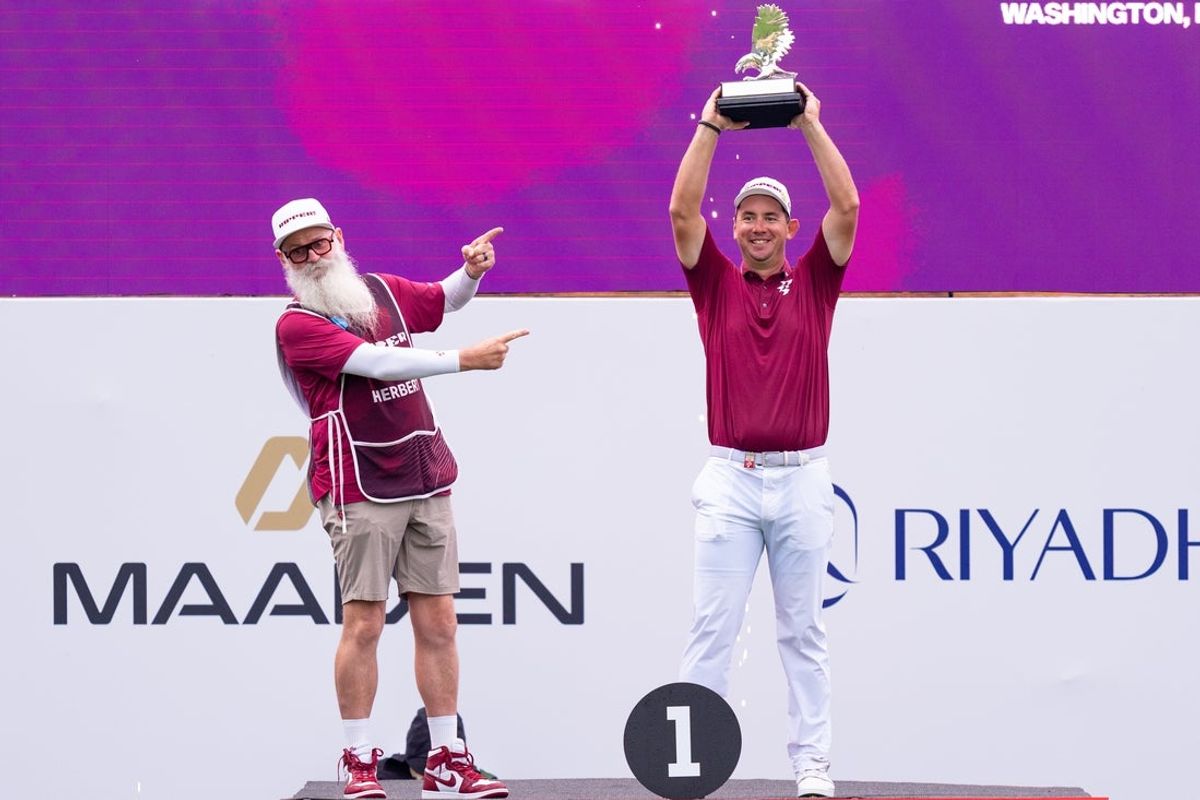 May 10, 2026; Sterling, Virginia, USA; Lucas  Herbert lifts his trophy in the air after the final round of LIV Golf Virginia golf tournament at Trump National Golf Club. Mandatory Credit: Jack Power-Imagn Images