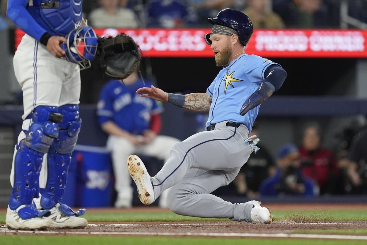 May 11, 2026; Toronto, Ontario, CAN; Tampa  Bay Rays right fielder Jake Fraley (17) slides in to home plate to score against the Toronto Blue Jays during the first inning at Rogers Centre. Mandatory Credit: John E. Sokolowski-Imagn Images