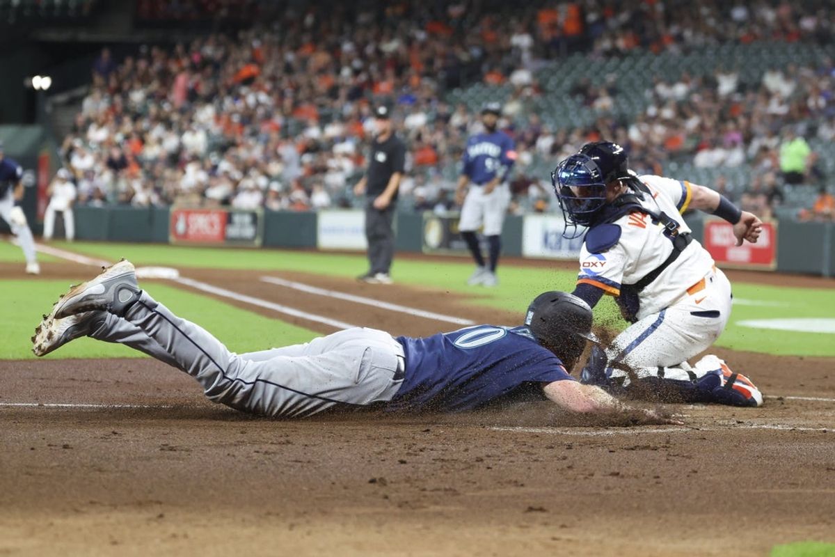 May 11, 2026; Houston, Texas, USA; Seattle Mariners right fielder Luke Raley (20) slides safely to score a run as Houston Astros catcher Christian Vazquez (2) attemtps to apply a tag during the second inning at Daikin Park. Mandatory Credit: Troy Taormina-Imagn Images