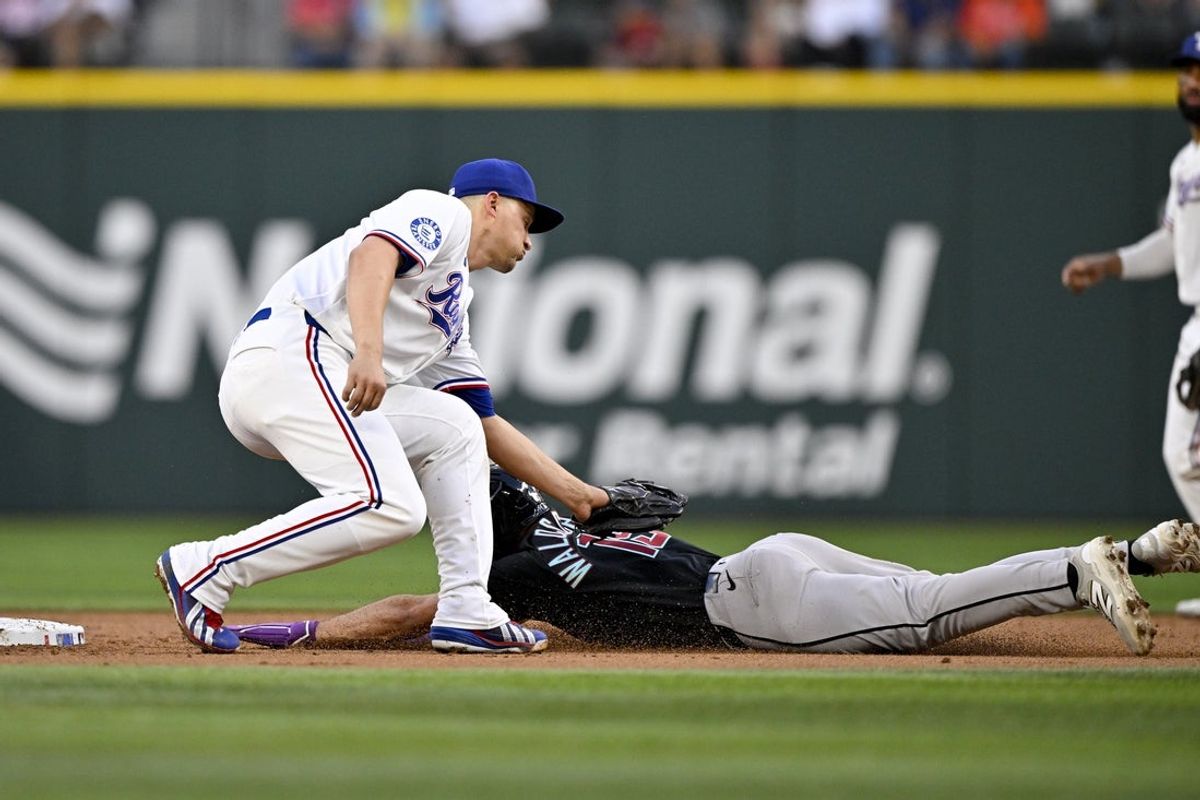 May 13, 2026; Arlington, Texas, USA;  Texas Rangers shortstop Corey Seager (5) tags out Arizona Diamondbacks center fielder Ryan Waldschmidt (15) on a steal attempt during the third inning at Globe Life Field. Mandatory Credit: Jerome Miron-Imagn Images
