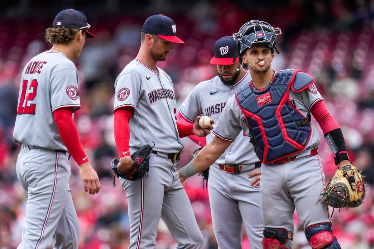 Washington Nationals pitcher Foster Griffin (22) is visited at the mound before being relieved in the fifth inning of the MLB National League game between the Cincinnati Reds and the Washington Nationals at Great American Ball Park in downtown Cincinnati on Thursday, May 14, 2026. The Reds led 2-0 after three innings. The Reds won 15-1.