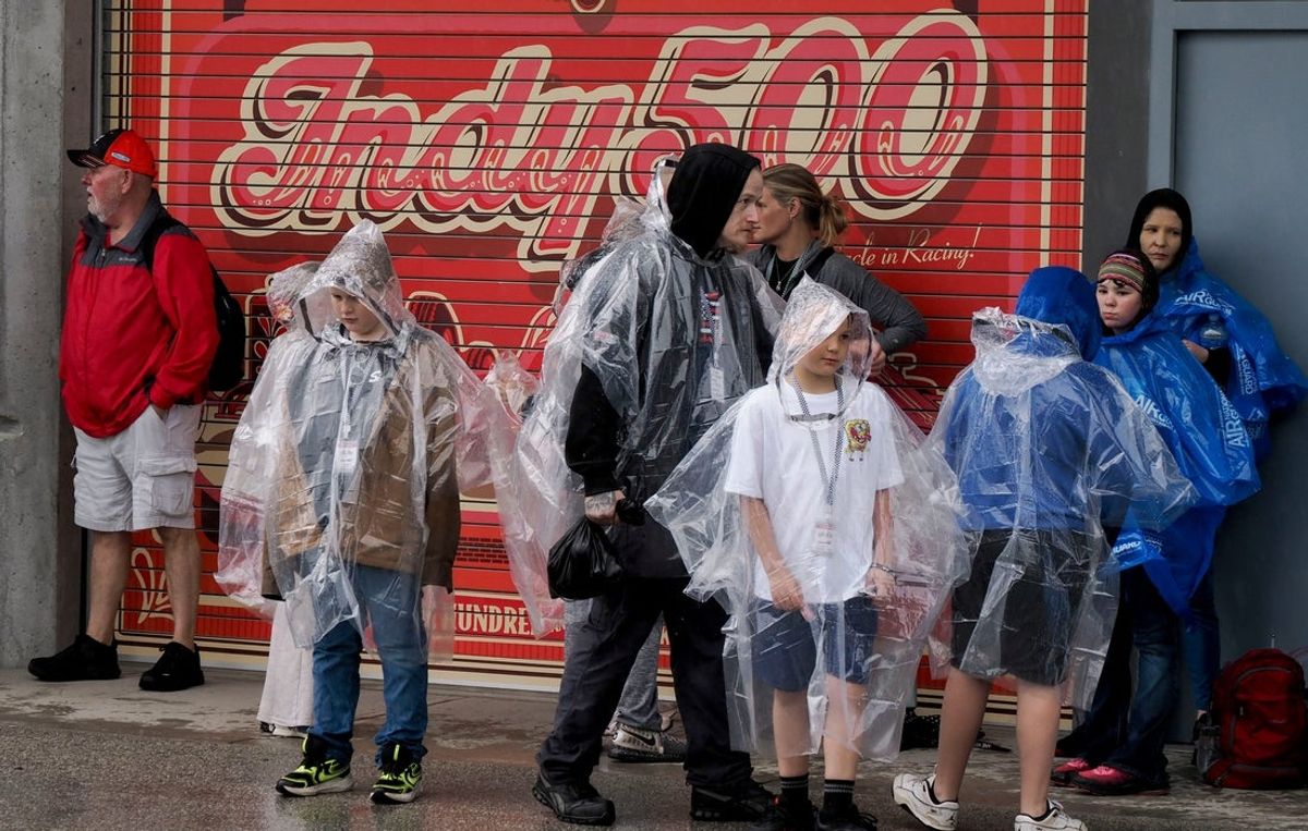Fans move through the rain Friday, May 15, 2026, before Fast Friday practice ahead of the 110th running of the Indianapolis 500 at Indianapolis Motor Speedway.