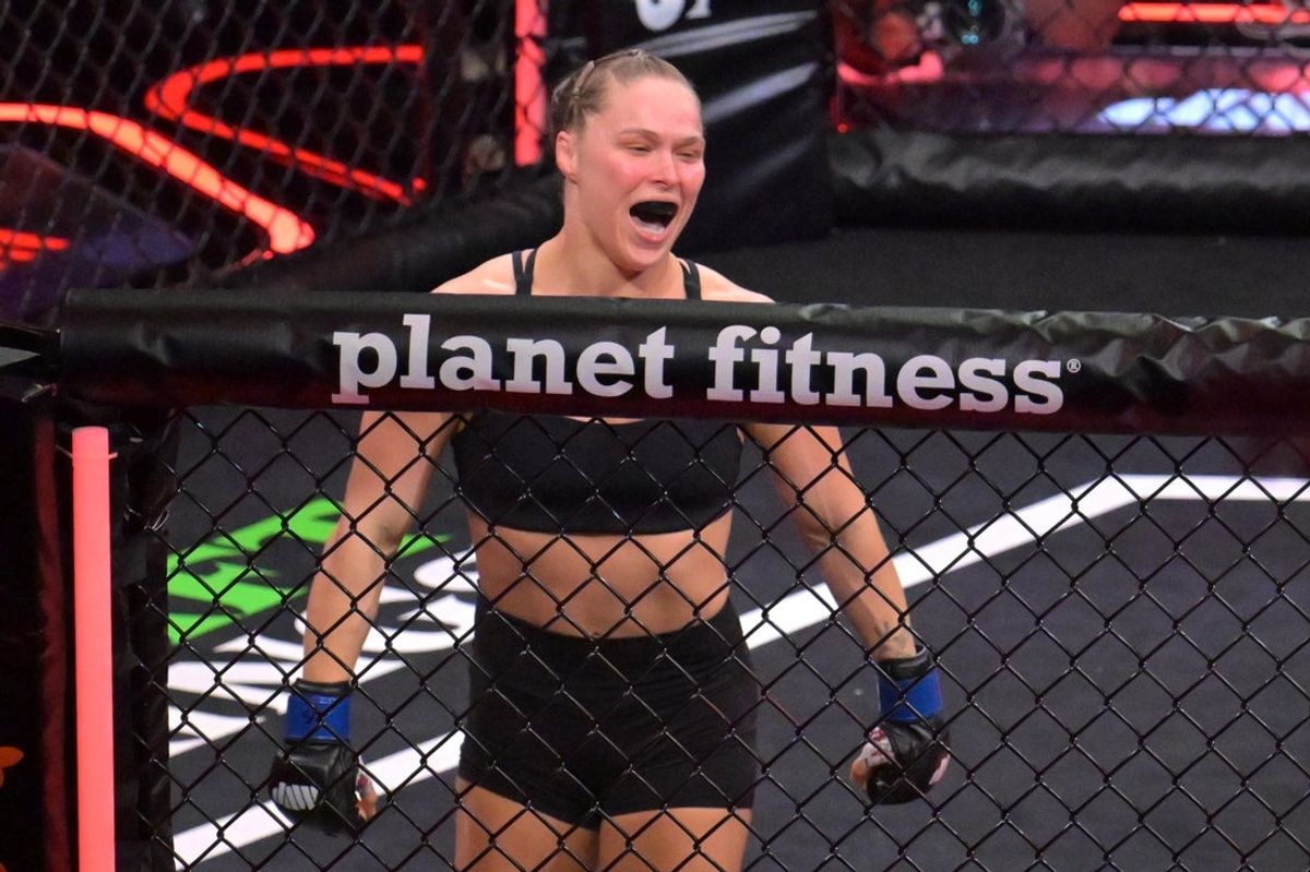 May 16, 2026; Los Angeles, California, USA;  Ronda Rousey (blue gloves) celebrates defeating Gina Carano (red gloves) after a women's featherweight bout at Intuit Dome. Mandatory Credit: Jayne Kamin-Oncea-Imagn Images