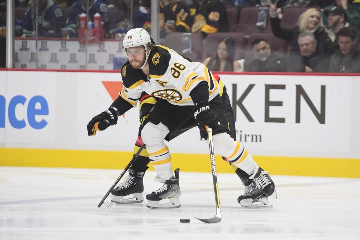 Feb 25, 2023; Vancouver, British Columbia, CAN;  Boston Bruins forward David Pastrnak  (88) reaches for the puck against the Vancouver Canucks during the first period at Rogers Arena.