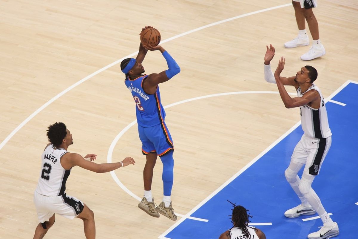 May 20, 2026; Oklahoma City, Oklahoma, USA; Oklahoma City Thunder guard Shai Gilgeous-Alexander (2) shoots as San Antonio Spurs forward Victor Wembanyama (1) defends during the first quarter during game two of the western conference finals for the 2026 NBA playoffs at Paycom Center. Mandatory Credit: Brett Rojo-Imagn Images