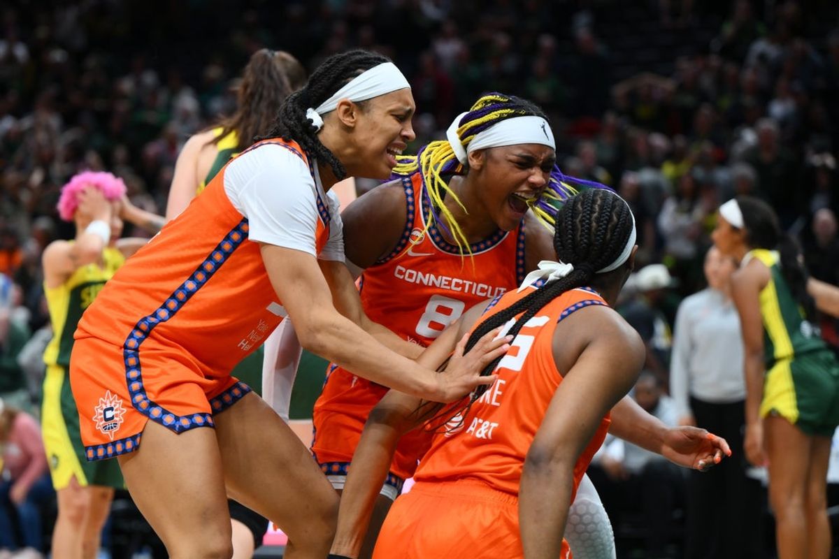 May 20, 2026; Seattle, Washington, USA; Connecticut Sun forward Nell Angloma (33) and forward Aaliyah Edwards (8) celebrate with guard Kennedy Burke (25) after Burke scored a basket to take the lead with 2.8 second left in the game against the Seattle Storm during the second half at Climate Pledge Arena. Mandatory Credit: Steven Bisig-Imagn Images