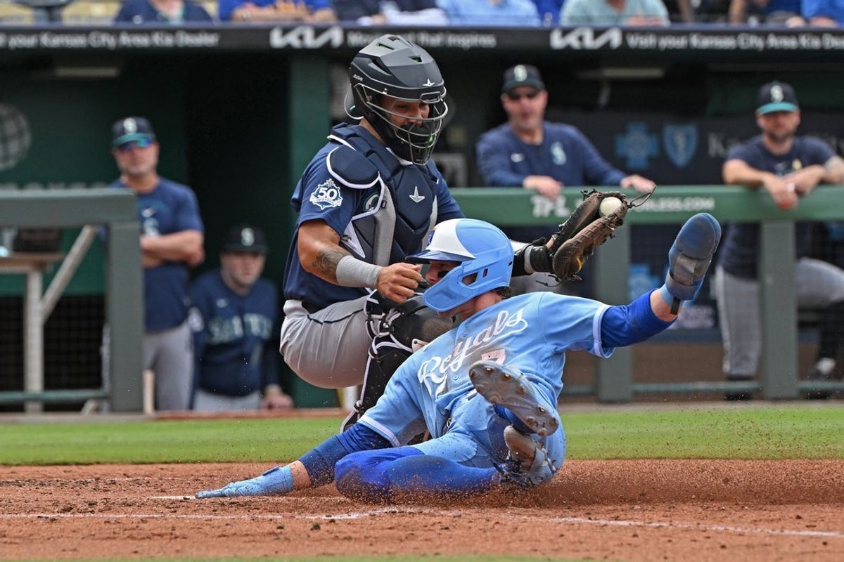 May 23, 2026; Kansas City, Missouri, USA;  Kansas City Royals shortstop Bobby Witt Jr. (7) slides at home plate to score a run in the third inning against Seattle Mariners catcher Jhonny Pereda (5) at Kauffman Stadium. Mandatory Credit: Peter Aiken-Imagn Images