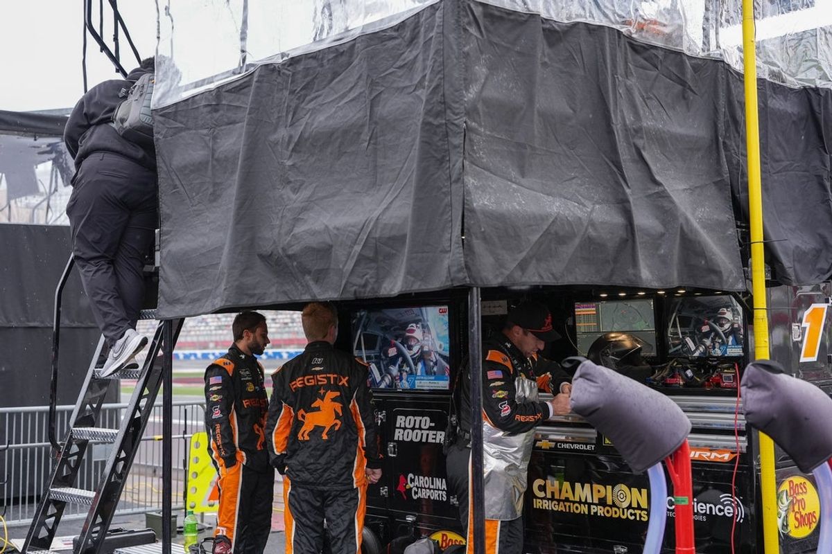 May 23, 2026; Concord, North Carolina, USA; NASCAR Xfinity Series 2026 driver Connor Zilisch (1) crew tries to stay dry during the Charbroil 300 at Charlotte Motor Speedway. Mandatory Credit: Jim Dedmon-Imagn Images