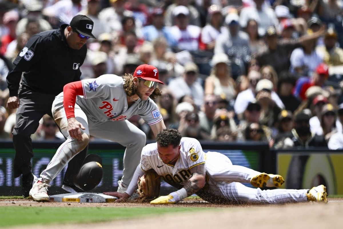 May 27, 2026; San Diego, California, USA; San Diego Padres center fielder Jackson Merrill (3) slides into third base ahead of the the tag of Philadelphia Phillies third baseman Alec Bohm (28) during the second inning at Petco Park. Mandatory Credit: Denis Poroy-Imagn Images