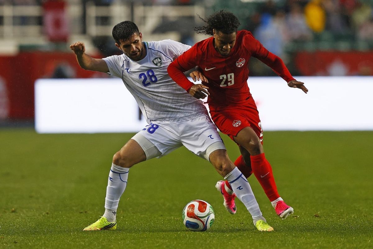 Jun 1, 2026; Edmonton, Ontario, CAN; Team Canada forward Jayden Nelson (29) and Uzbekistan defender Aziz Amonov (28) battle for a loose ball during the second half at Commonwealth Stadium. Mandatory Credit: Perry Nelson-Imagn Images