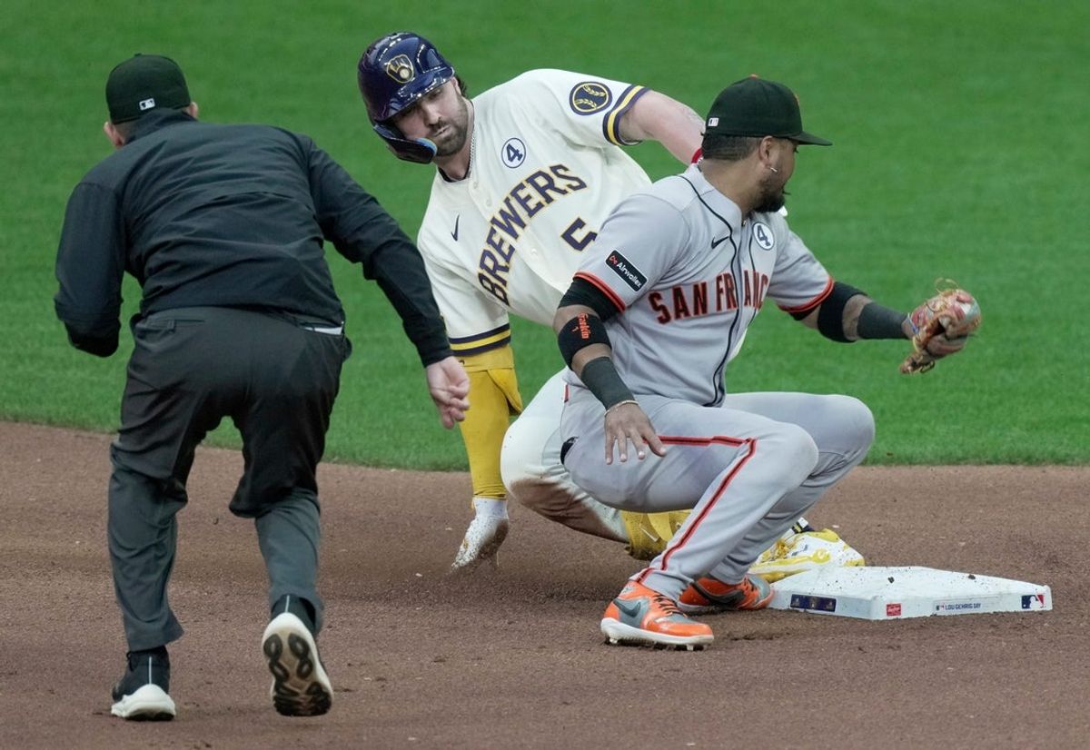 Milwaukee Brewers center fielder Garrett Mitchell (5) beats a tag by San Francisco Giants second baseman Luis Arraez (1) for a double during the fourth inning of their game Tuesday, June 2, 2026 at American Family Field in Milwaukee, Wisconsin.
