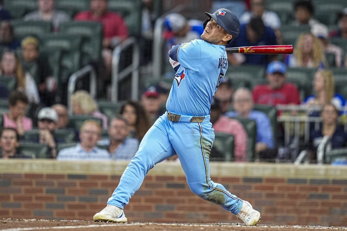 Jun 2, 2026; Cumberland, Georgia, USA; Toronto Blue Jays center fielder Daulton Varsho (5) hits a sacrifice fly ball to drive in a run against the Atlanta Braves during the sixth inning at Truist Park. Mandatory Credit: Dale Zanine-Imagn Images