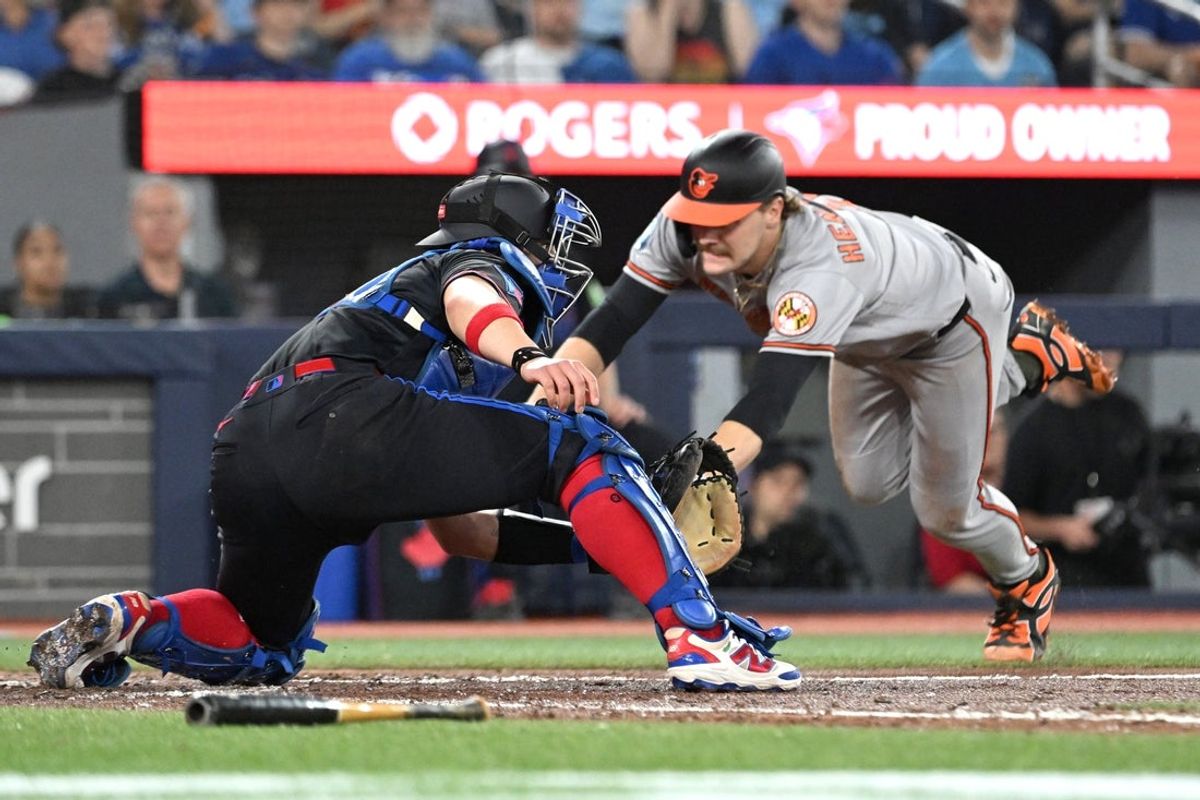 Jun 5, 2026; Toronto, Ontario, CAN;  Baltimore Orioles shortstop Gunnar Henderson (2) dives into home plate to score a run ahead of the tag from Toronto Blue Jays catcher Brandon Valenzuela (59) in the sixth inning at Rogers Centre. Mandatory Credit: Dan Hamilton-Imagn Images