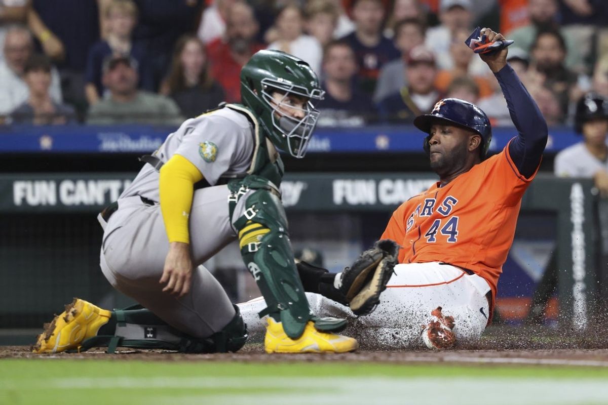 Jun 5, 2026; Houston, Texas, USA; Houston Astros left fielder Yordan Alvarez (44) slides safely past Athletics catcher Shea Langeliers (23) to score a run during the third inning at Daikin Park. Mandatory Credit: Troy Taormina-Imagn Images