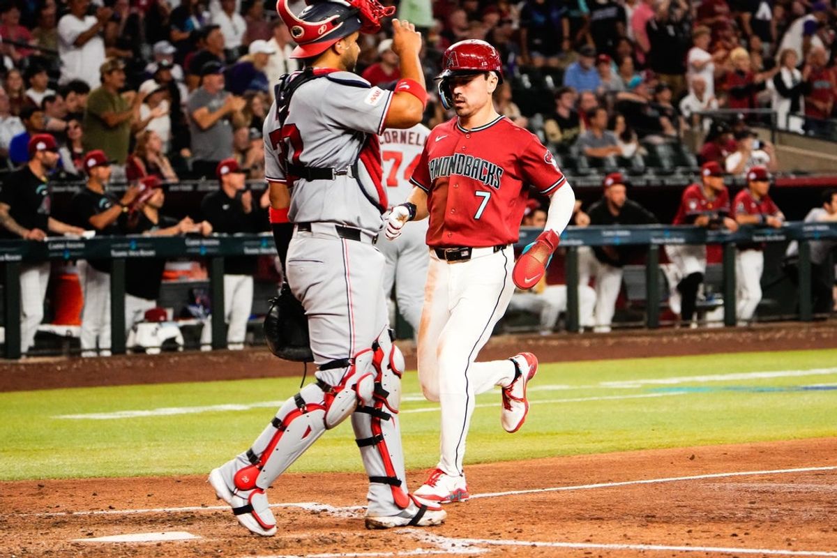 Jun 7, 2026; Phoenix, Arizona, USA; Arizona Diamondbacks first baseman Pavin Smith (26) hits a sac-fly to bring home right fielder Corbin Carroll (7) during the seventh inning at Chase Field against the Washington Nationals. Mandatory Credit: Arianna Grainey-Imagn Images