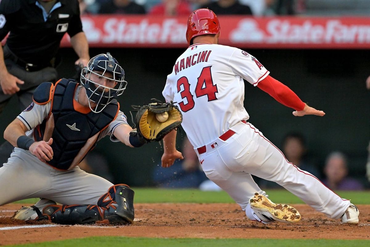Jun 8, 2026; Anaheim, California, USA;  Los Angeles Angels left fielder Trey Mancini (34) beats the tag by Houston Astros catcher Collin Price (37) for a run in the second inning at Angel Stadium. Mandatory Credit: Jayne Kamin-Oncea-Imagn Images