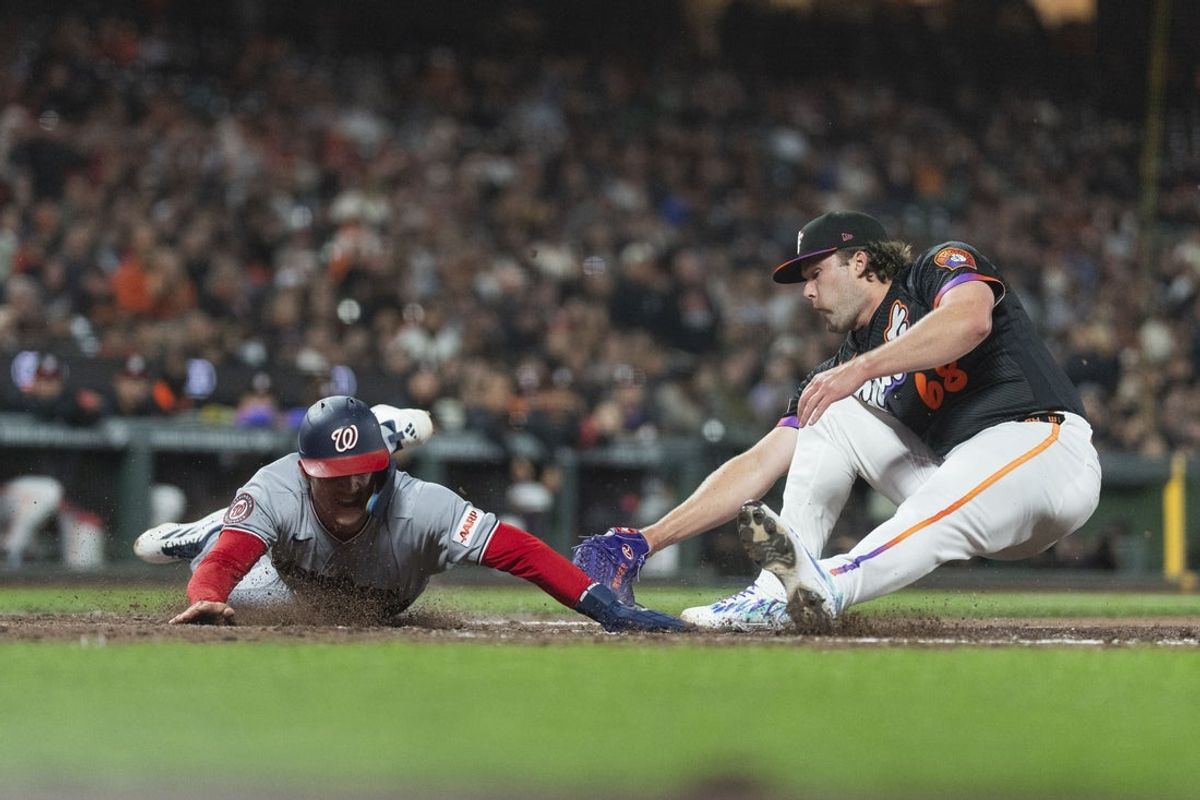 Jun 9, 2026; San Francisco, California, USA;  Washington Nationals center fielder Jacob Young (30) dives in safe towards home plate during the seventh inning against San Francisco Giants pitcher Erik Miller (68) at Oracle Park. Mandatory Credit: Stan Szeto-Imagn Images