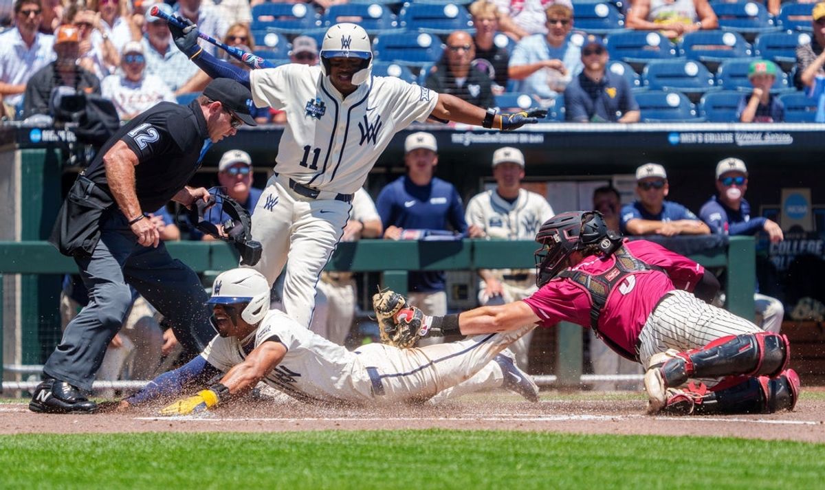 Jun 12, 2026; Omaha, NE, USA; West Virginia Mountaineers right fielder Armani Guzman (5) steals home to score against Troy Trojans catcher Jimmy Janicki (5) during the first inning at Charles Schwab Field. Mandatory Credit: Dylan Widger-Imagn Images