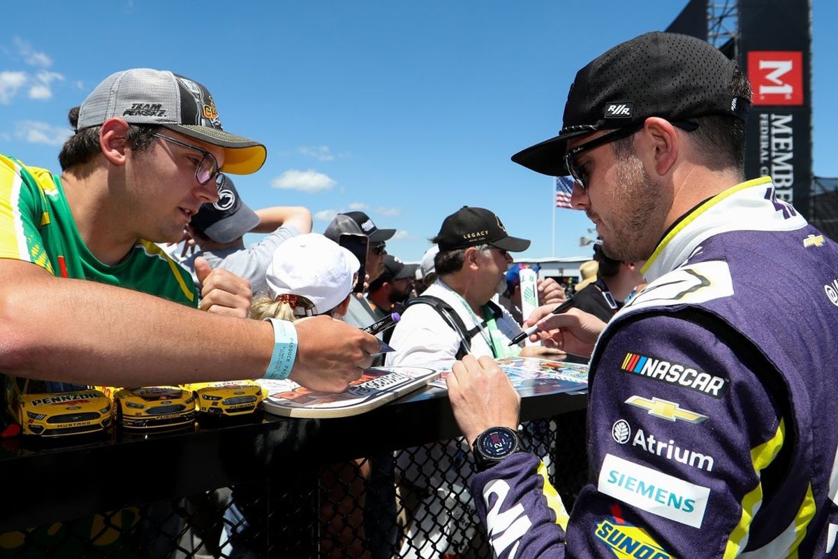 Jun 13, 2026; Long Pond, Pennsylvania, USA; NASCAR Cup Series driver Alex Bowman signs an autograph for a fan during practice and qualifying for The Great American Getaway 400 at Pocono Raceway. Mandatory Credit: Matthew O'Haren-Imagn Images