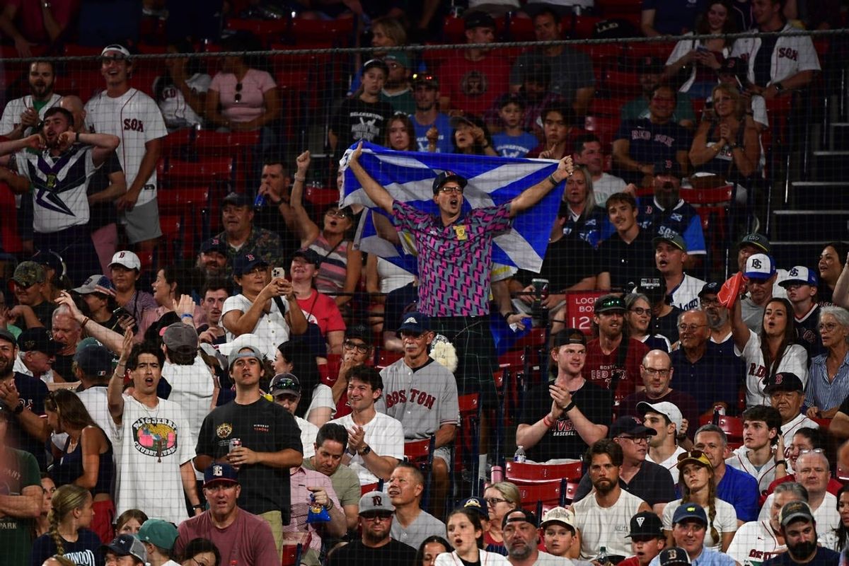 Jun 14, 2026; Boston, Massachusetts, USA;  A fan holds a Scottish flag during the eighth inning in a game between the Boston Red Sox and Texas Rangers at Fenway Park. Mandatory Credit: Bob DeChiara-Imagn Images