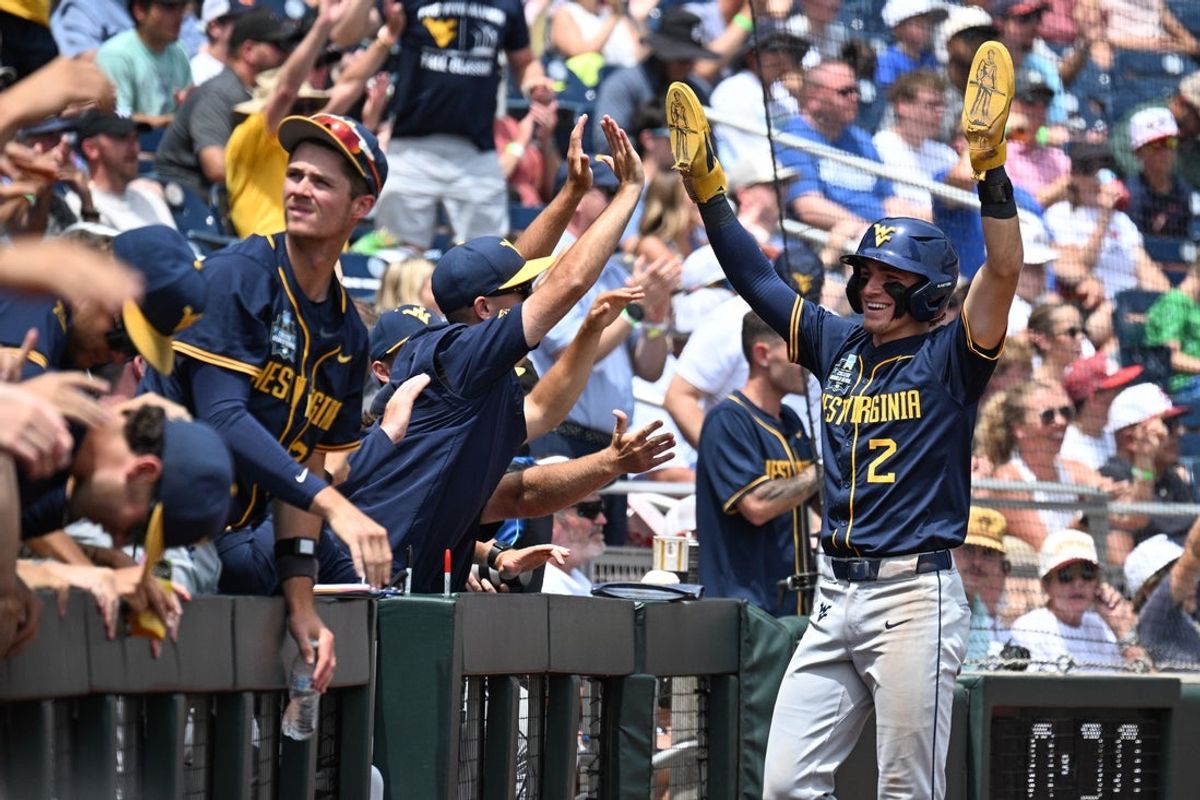 Jun 16, 2026; Omaha, NE, USA;  West Virginia Mountaineers second baseman Gavin Kelly (2) reacts with teammate after scoring against the Troy Trojans during the second inning at Charles Schwab Field. Mandatory Credit: Steven Branscombe-Imagn Images