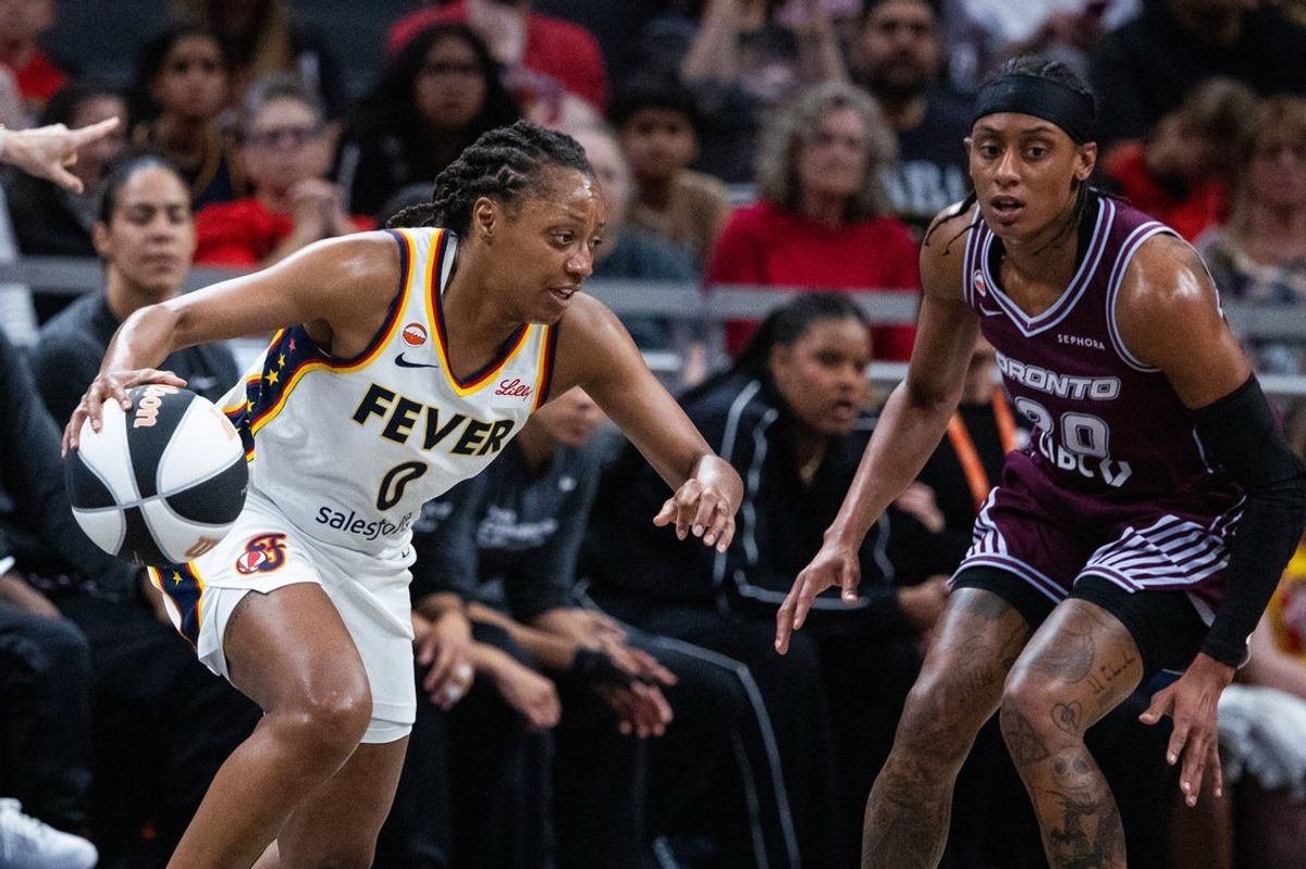 Jun 16, 2026; Indianapolis, Indiana, USA;  Indiana Fever guard Kelsey Mitchell (0) dribbles the ball while Toronto Tempo guard Brittney Sykes (20) defends in the first half at Gainbridge Fieldhouse. Mandatory Credit: Trevor Ruszkowski-Imagn Images