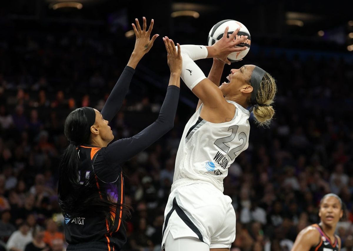 17 de junho de 2026; Phoenix, Arizona, EUA; O pivô do Las Vegas Aces, A'ja Wilson (22), chuta a bola contra o atacante do Phoenix Mercury, DeWanna Bonner (24), no primeiro tempo no Mortgage Matchup Center. Crédito obrigatório: Mark J. Rebilas-Imagn Images