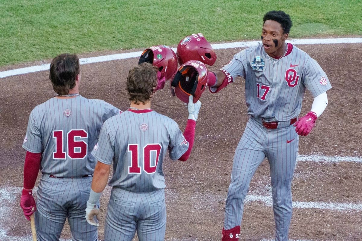 17 de junho de 2026; Omaha, NE, EUA; O defensor direito do Oklahoma Sooners, Dasan Harris (17), comemora com o primeiro base Dayton Tockey (16) e o defensor esquerdo Brendan Brock (10) após um home run de três corridas de Harris contra o Georgia Bulldogs durante a quarta entrada no Charles Schwab Field. Crédito obrigatório: Dylan Widger-Imagn Images