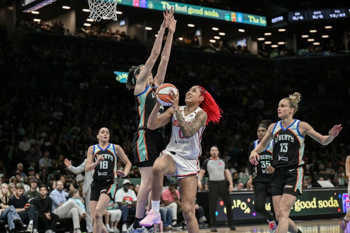 19 de junho de 2026; Brooklyn, Nova York, EUA; Shakira Austin (0), central do Washington Mystics, chuta a bola enquanto é defendida pela atacante do New York Liberty, Breanna Stewart (30), durante o primeiro tempo no Barclays Center. Crédito obrigatório: John Jones-Imagn Images