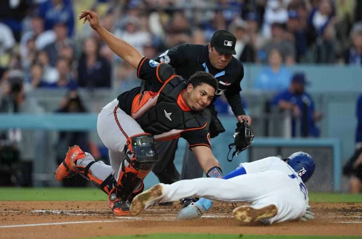 19 de junho de 2026; Los Angeles, Califórnia, EUA; O jogador da segunda base do Los Angeles Dodgers, Alex Freeland (76), marca contra o apanhador do Baltimore Orioles, Samuel Basallo (29), durante o segundo turno no Dodger Stadium. Crédito obrigatório: Kirby Lee-Imagn Images