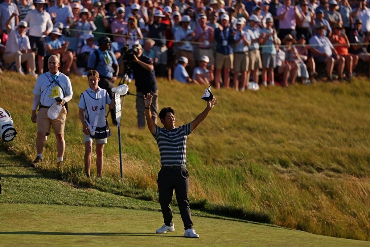 Jun 21, 2026; Southampton, New York, USA; Tom Kim waves in gratitiude to the patrons after they sing happy birthday during the final round of the U.S. Open golf tournament at Shinnecock Hills Golf Club. Mandatory Credit: Bill Streicher-Imagn Images