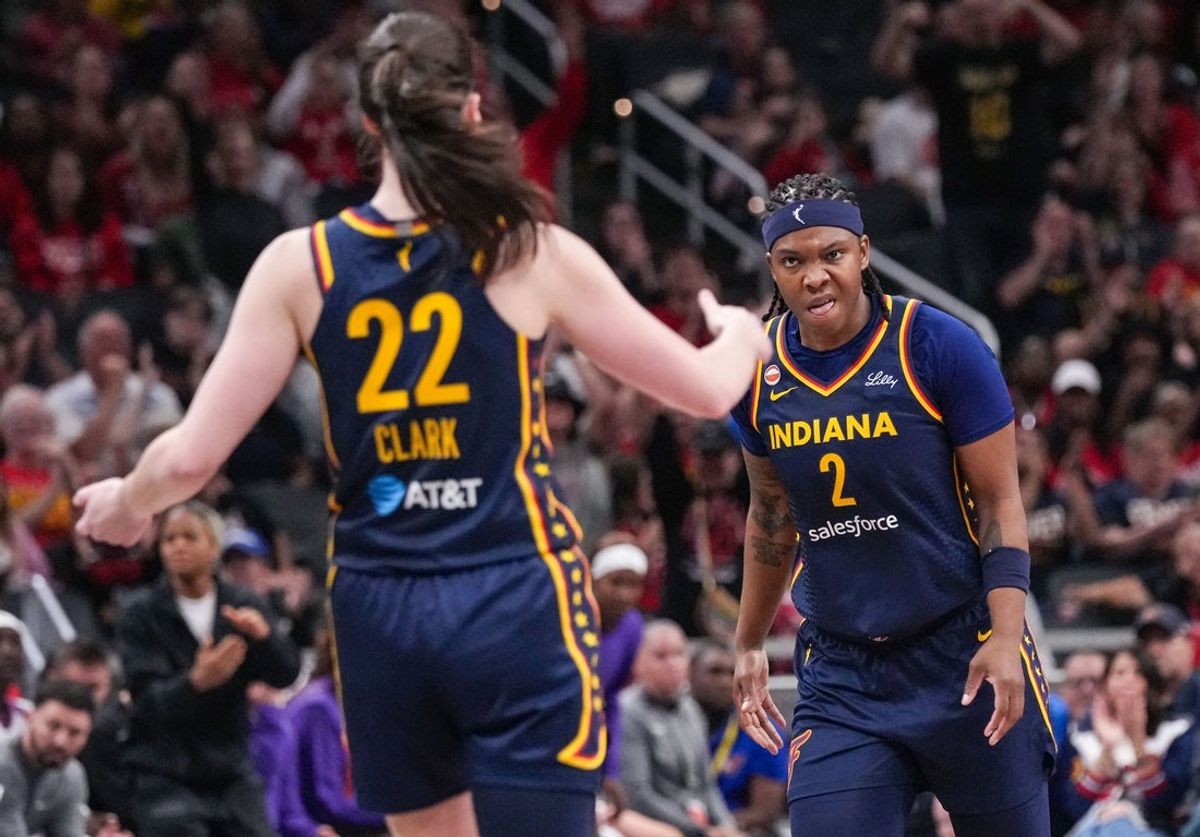 A atacante do Indiana Fever, Myisha Hines-Allen (2), comemora com a guarda do Indiana Fever, Caitlin Clark (22), após uma assistência para levar a uma cesta de três pontos na segunda-feira, 22 de junho de 2026, durante o jogo no Gainbridge Fieldhouse, em Indianápolis.