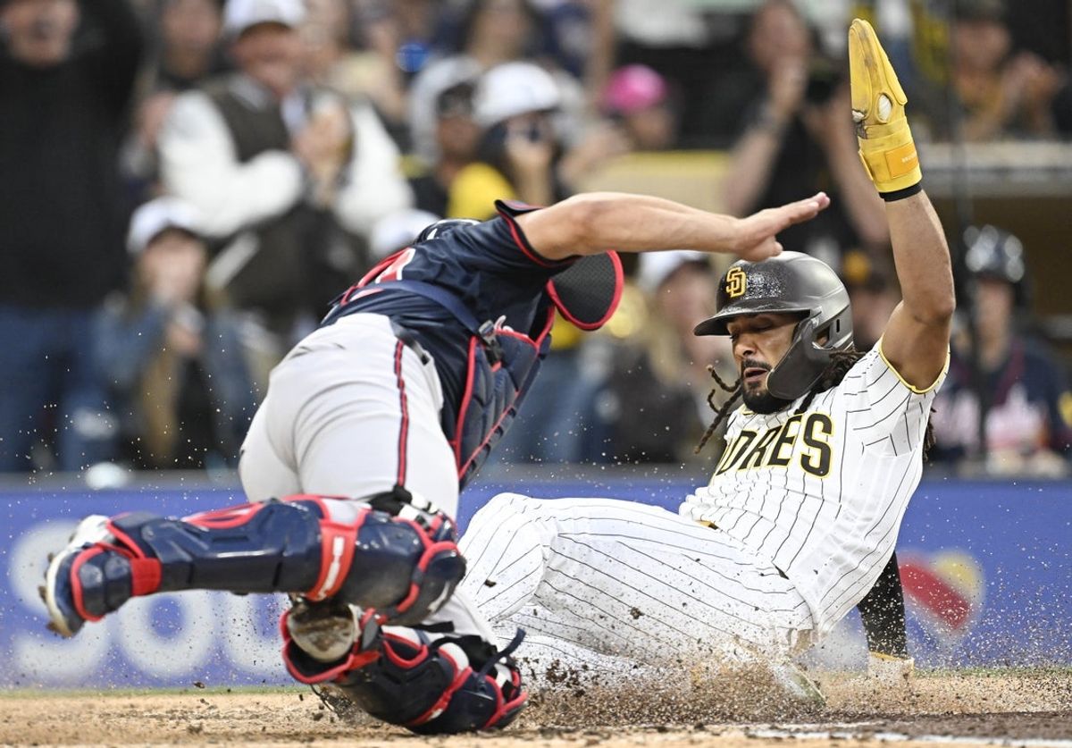 23 de junho de 2026; San Diego, Califórnia, EUA; O defensor direito do San Diego Padres, Fernando Tatis Jr. (23), marca à frente do apanhador do Atlanta Braves, Drake Baldwin (30), durante a segunda entrada no Petco Park. Crédito obrigatório: Denis Poroy-Imagn Images