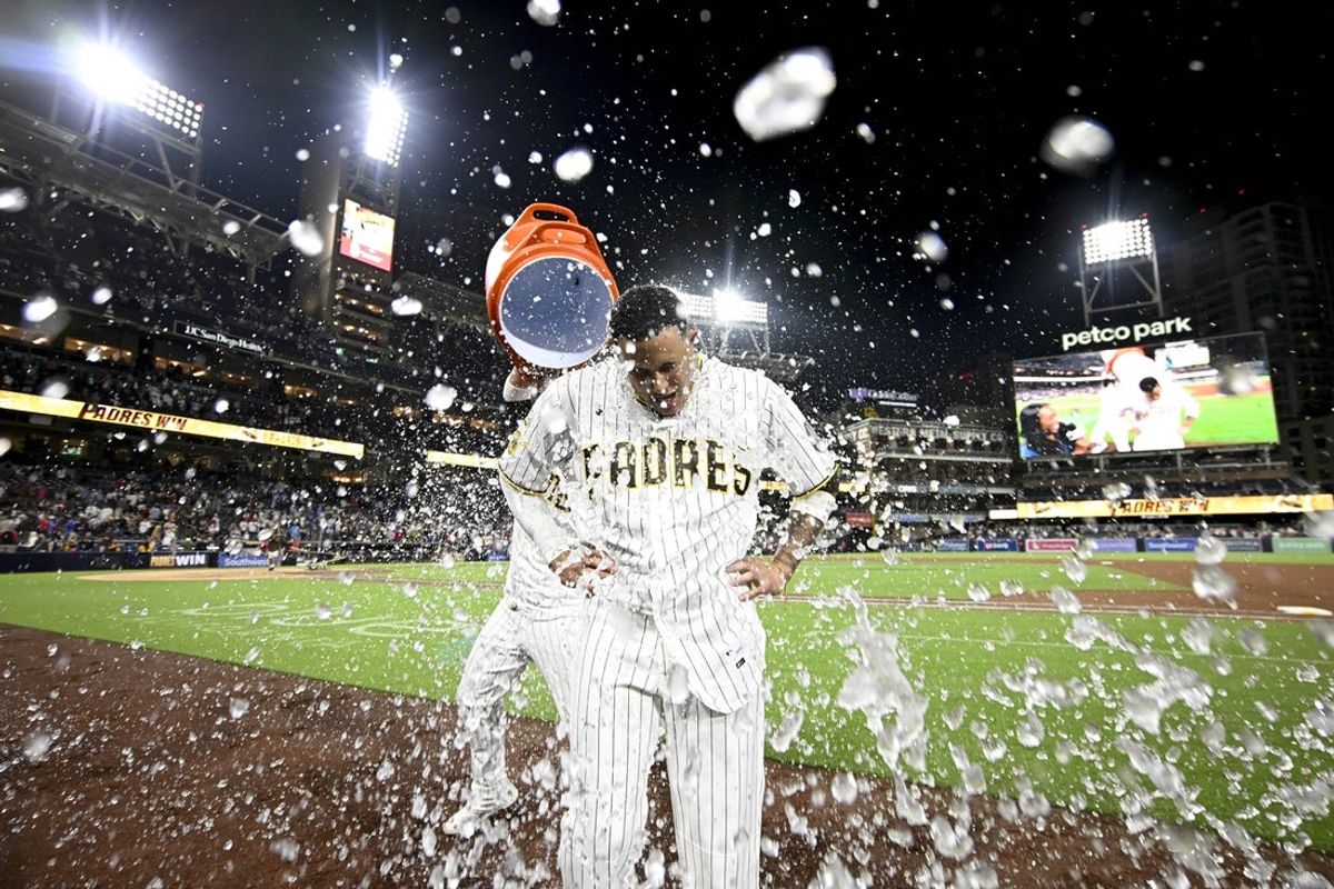 23 de junho de 2026; San Diego, Califórnia, EUA; O terceiro base do San Diego Padres, Manny Machado (13), leva um cooler jogado sobre ele depois de acertar um walk-off single contra o Atlanta Braves no Petco Park. Crédito obrigatório: Denis Poroy-Imagn Images