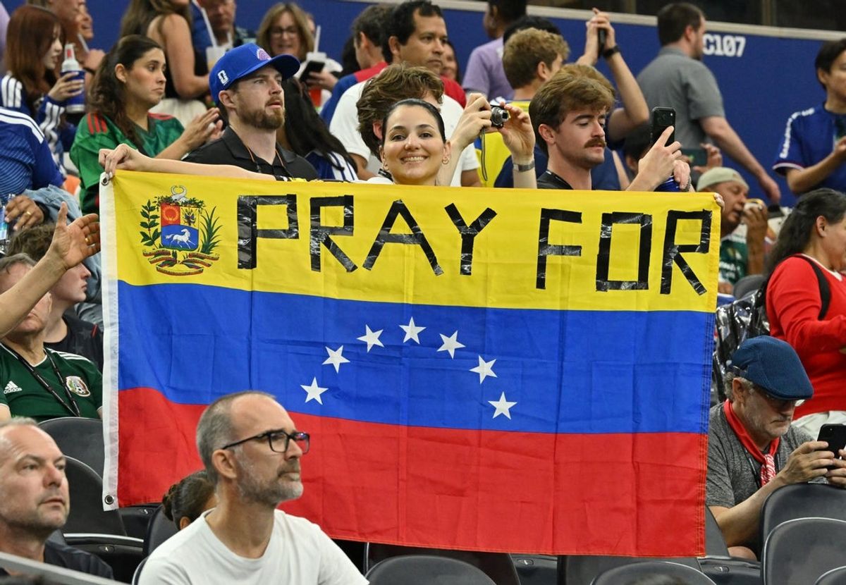 25 de junho de 2026; Arlington, Texas, EUA; Um torcedor exibe a bandeira da Venezuela dentro do estádio antes da partida em homenagem às vítimas do terremoto. Crédito obrigatório: Jerome Miron-Imagn Images