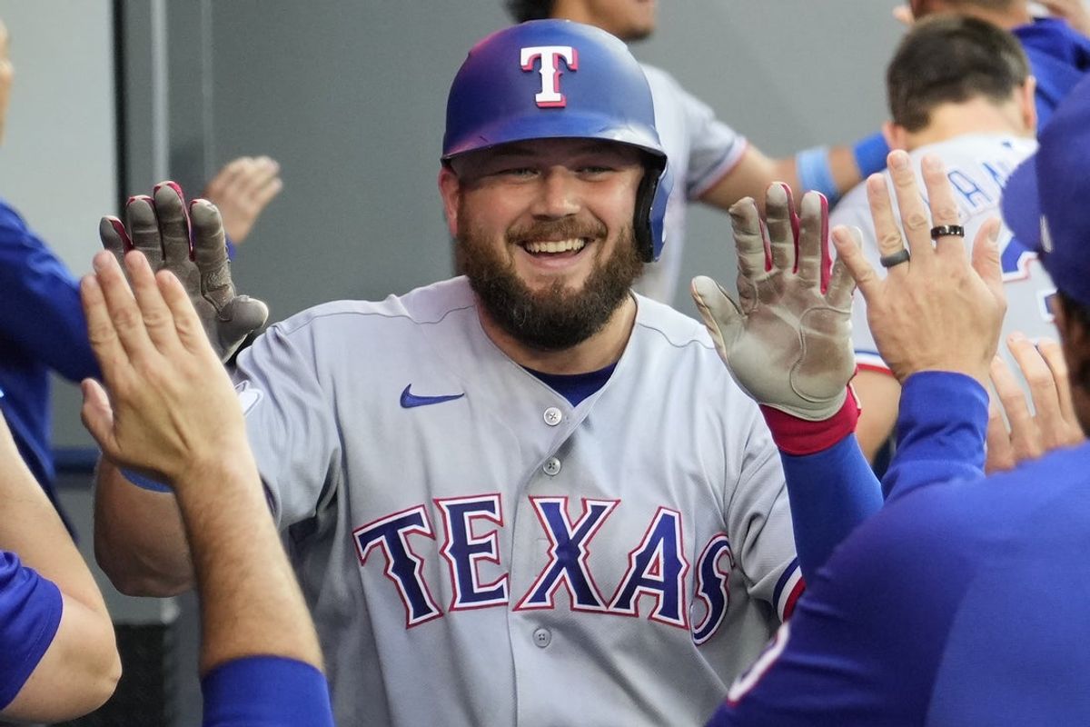 25 de junho de 2026; Toronto, Ontário, CAN; O jogador da primeira base do Texas Rangers, Jake Burger (21), é parabenizado depois de acertar um home run de duas corridas contra o Toronto Blue Jays durante a terceira entrada no Rogers Centre. Crédito obrigatório: John E. Sokolowski-Imagn Images