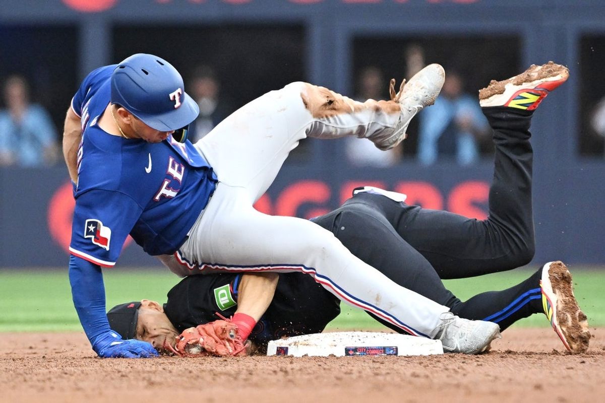 26 de junho de 2026; Toronto, Ontário, CAN; O defensor central do Texas Rangers, Wyatt Langford (36), cai sobre o segunda base do Toronto Blue Jays, Andres Gimenez (0), depois de ser eliminado ao tentar roubar a segunda base no segundo turno no Rogers Centre. Crédito obrigatório: Dan Hamilton-Imagn Images